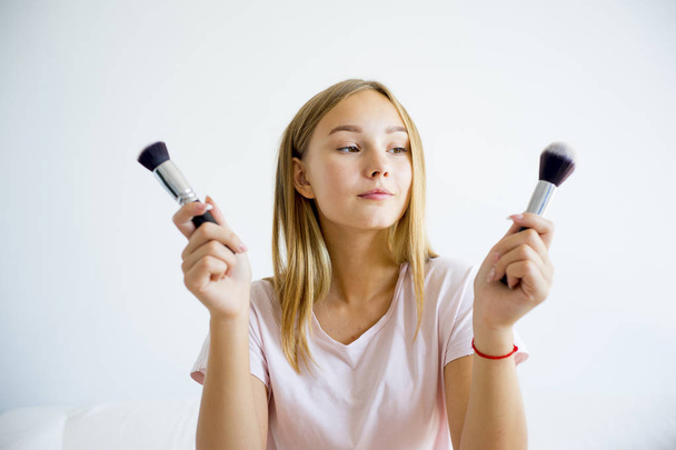 Girl applying makeup - Foto, afbeelding