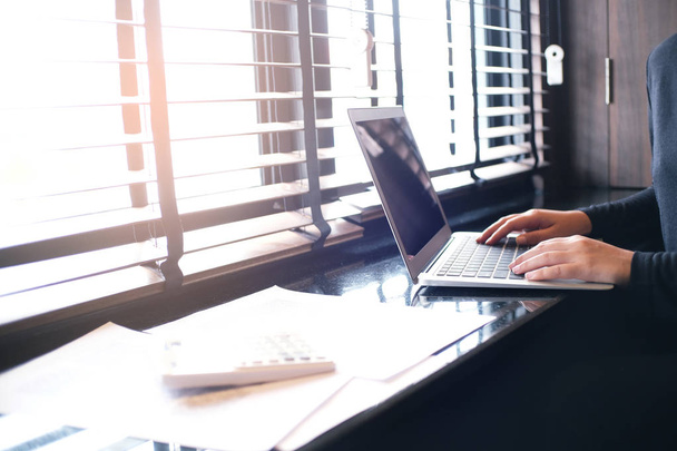 Случайная деловая женщина работает в Интернете на ноутбуке, рука на клавиатуре
 - Фото, изображение