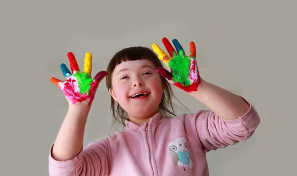 schattig klein meisje met geschilderde handen. geïsoleerd op grijze achtergrond.  - Foto, afbeelding