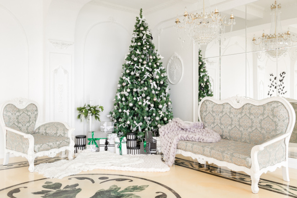 Ylellinen huoneisto koristeltu jouluksi. Joulukuusi lahjoja alla olohuoneessa
 - Valokuva, kuva