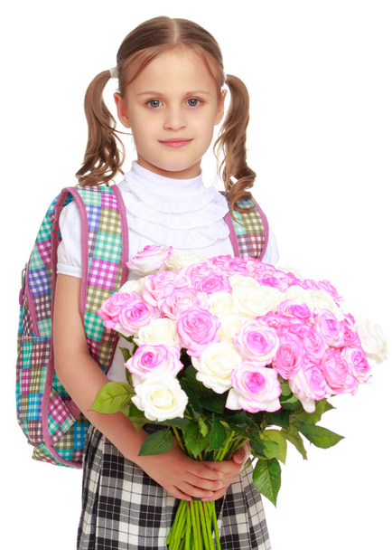 Little girl schoolgirl with flowers - Фото, изображение