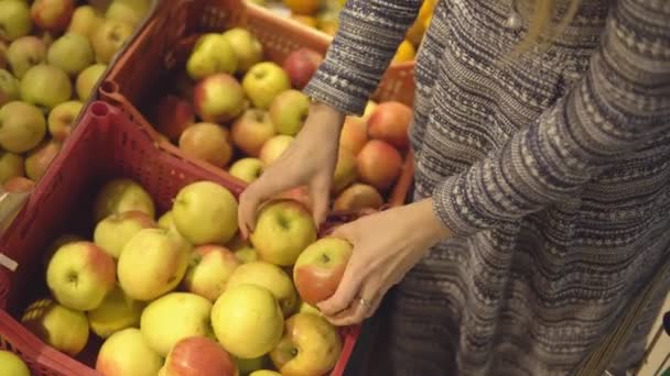 ręce kobiety wybierając apple w supermarkecie warzyw owoców - Materiał filmowy, wideo