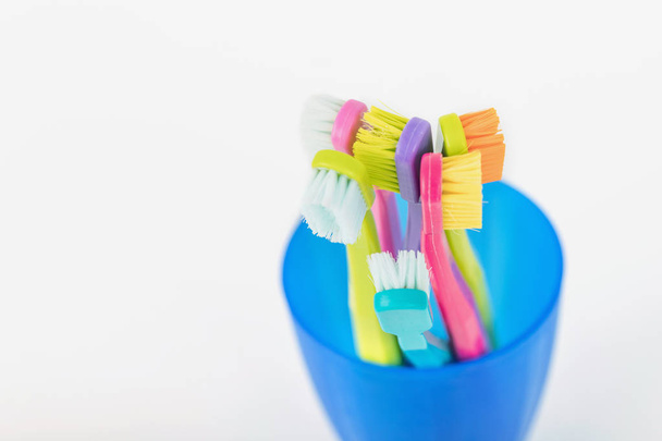 New and used color ultra fine toothbrushes in colorful glasses.  - Photo, Image