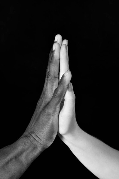 A hands of black man and white woman on black background - Fotoğraf, Görsel