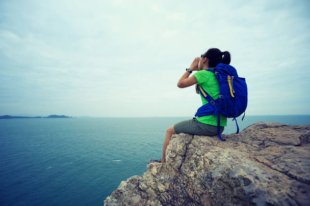Молодая женщина турист кричит на вершине скалы на берегу моря
 - Фото, изображение