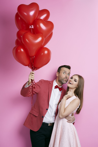 Couple affectueux avec des ballons en forme de coeur flirtant
  - Photo, image