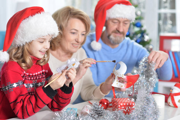 grandparents with granddaughter preparing for Christmas  - Фото, изображение