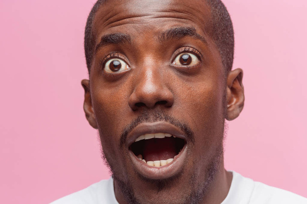 The portrait of handsome young surprised black african man - 写真・画像