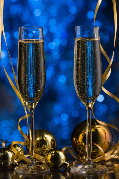 zwei Gläser Champagner mit blauem Bokeh-Hintergrund, festliche Dekoration, Weihnachtsspielzeug - Foto, Bild