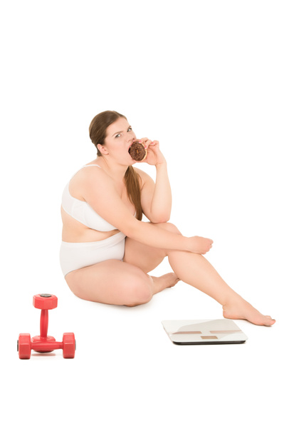 mujer con sobrepeso con rosquilla, mancuernas y escamas
 - Foto, imagen