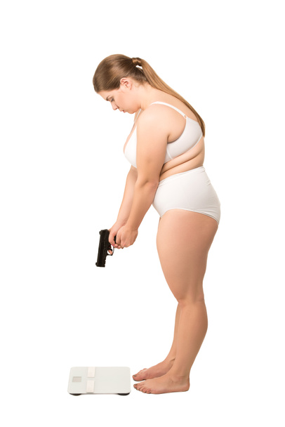woman with gun standing at scales - Foto, imagen