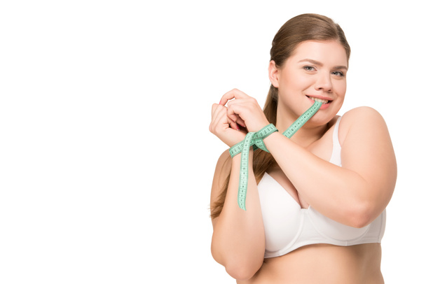 太りすぎの測定テープをかむ女性 - 写真・画像