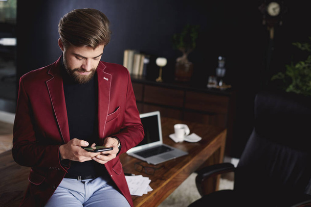 Schlauer Geschäftsmann nutzt Smartphone während einer kurzen Pause  - Foto, Bild