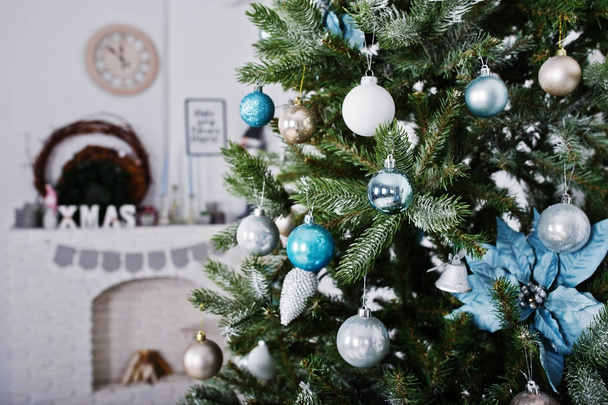 Игрушки на новогоднем дереве в белой комнате. Счастливые зимние каникулы
 - Фото, изображение