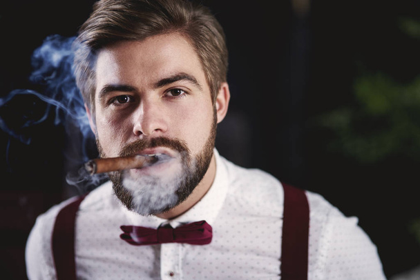 Vue de face du bel homme fumant un cigare cubain
 - Photo, image
