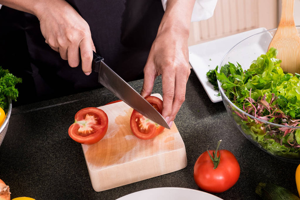 Healthy Woman fait une salade de légumes frais avec de l'huile d'olive, tomate
 - Photo, image
