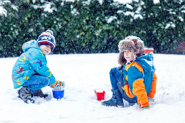Deux petits garçons jouant avec la neige à l'extérieur
 - Photo, image
