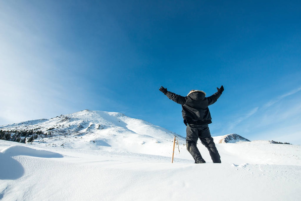 Happy climber with an ice ax in the snowy mountains - Foto, imagen