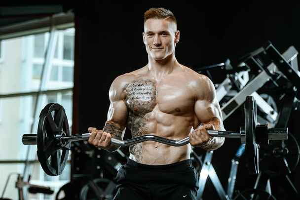 Handsome model young man working out in gym - Foto, afbeelding