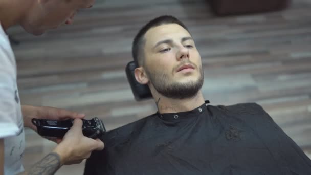 Young handsome man in barbershop - Materiał filmowy, wideo