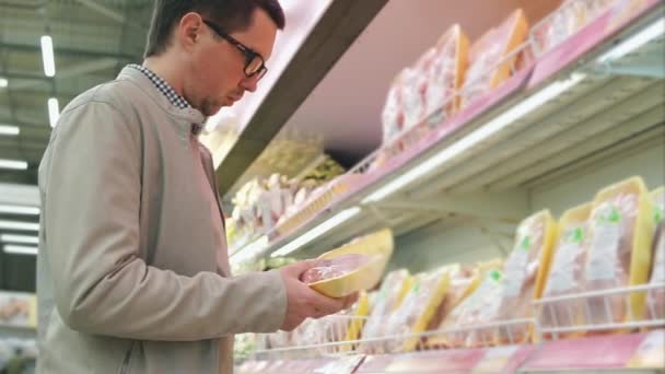 Hombre comprando carne de pollo en el supermercado
 - Imágenes, Vídeo