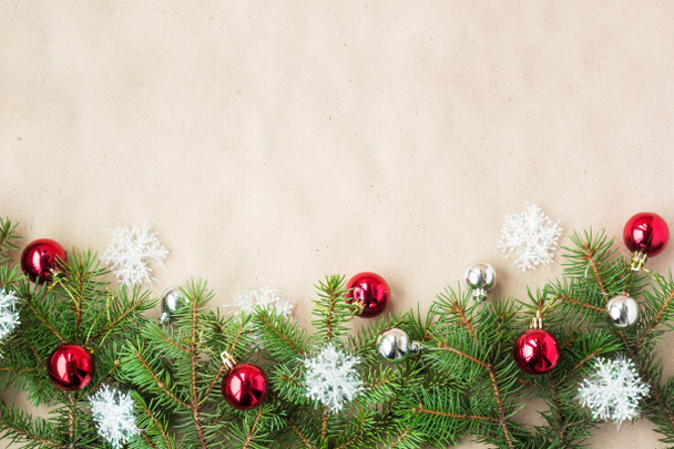 モミの枝に赤と銀のボールと素朴なベージュ色の背景に雪の結晶のお祝いクリスマス国境 - 写真・画像