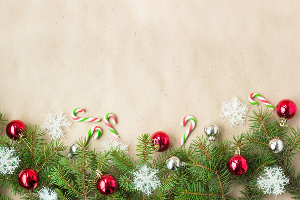 Świąteczna Boże Narodzenie granicy z czerwone i srebrne kulki na gałęzie jodły i płatki śniegu na rustykalne beżowym tle - Zdjęcie, obraz