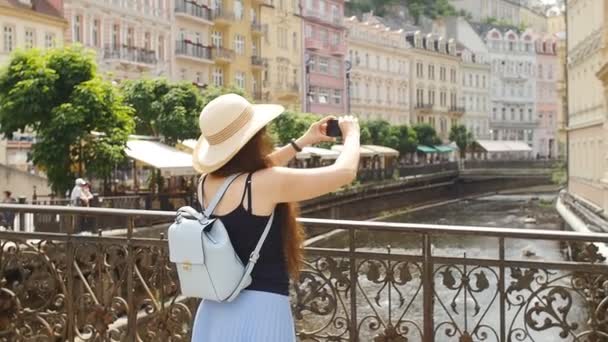 Cestování dívka používáte chytrý telefon k zachycení obrazu starého města - Záběry, video