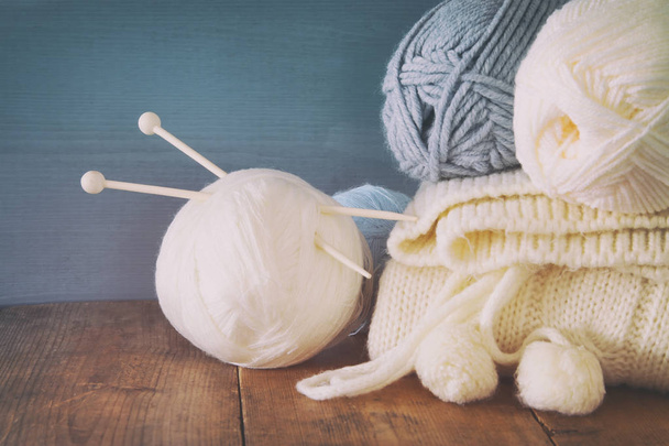warm and cozy yarn balls of wool on wooden table. - Фото, изображение