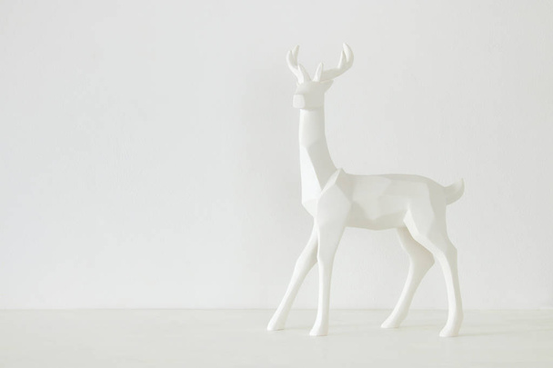 White reindeer on wooden table over white background - Fotoğraf, Görsel