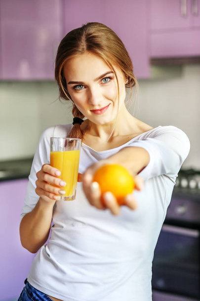 Молодая счастливая девушка с апельсиновым соком. Кухня. Концепция исцеления
 - Фото, изображение