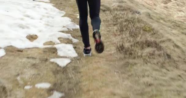 Atleta hombre corriendo a través de sendero nevado.Siguiendo detrás de las piernas detail.Real personas adulto trail runner entrenamiento deportivo en otoño o invierno en la naturaleza salvaje montaña al aire libre, mal tiempo niebla.
 - Metraje, vídeo