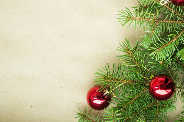 Fenyő fa ágai díszített piros karácsonyi golyó, mint egy rusztikus háttér kereten másol hely határon - Fotó, kép