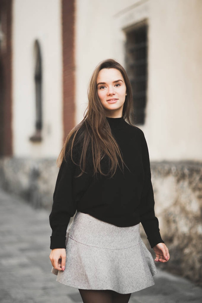 Beautiful young woman posing on the street in old city - Zdjęcie, obraz