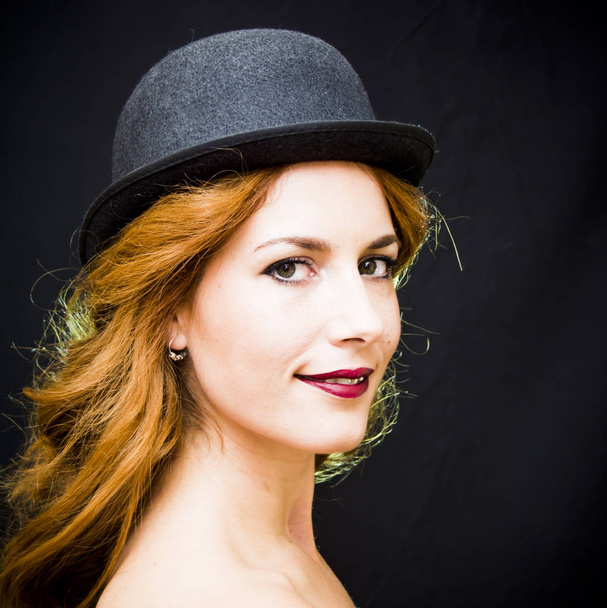 Portrait d'une belle femme avec chapeau sur fond noir
 - Photo, image