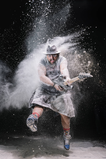 człowiek z gitarą między kreda kurz i dym - Zdjęcie, obraz