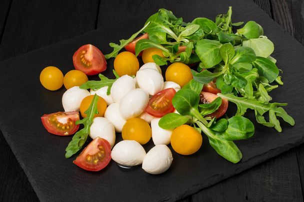 Mozzarella, tomatoes and different salad leaves  - Photo, Image
