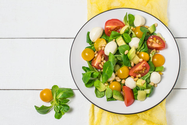frischer Salat mit Mozzarella, Tomaten, Avocado und Salat  - Foto, Bild