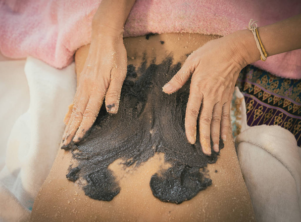 Spa Therapist applique le gommage de café au charbon sur une femme dos
 - Photo, image