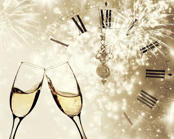 Vasos con champán y reloj cerca de medianoche
 - Foto, Imagen