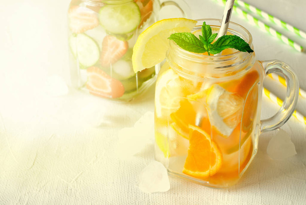 Summer refreshing iced drinks with orange, lemon, cucumber and strawberry on white background - Fotografie, Obrázek