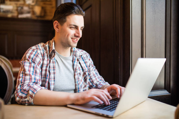 Uśmiechnięty mężczyzna korzysta z laptopa w pracy restauracji - Zdjęcie, obraz