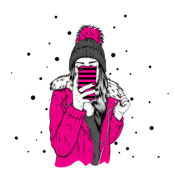 A girl in a stylish down jacket and a beautiful hat with a fluffy bubo. A woman is holding a smartphone and making selfies. Vector illustration. Clothing and accessories, fashion and style. - Вектор, зображення