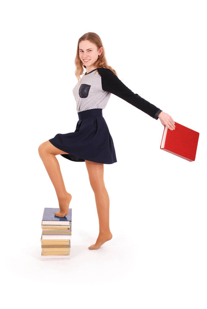 Освіта, люди, підліток і концепція школи дівчина-підліток стоїть на стеку книг
 - Фото, зображення