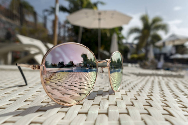 Sonnenbrille liegt am Pool auf einer Liege   - Foto, Bild