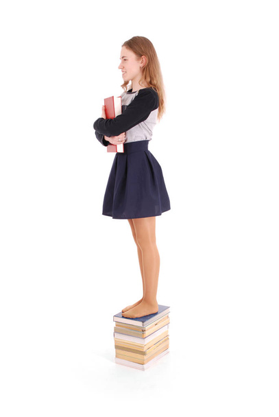 Education, people, teenager and school concept - teenager school girl standing on stack of books - Fotografie, Obrázek