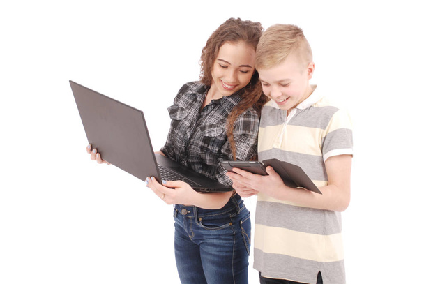 Двое детей играют и занимаются серфингом в Интернете на цифровом планшете и ноутбуке
. - Фото, изображение