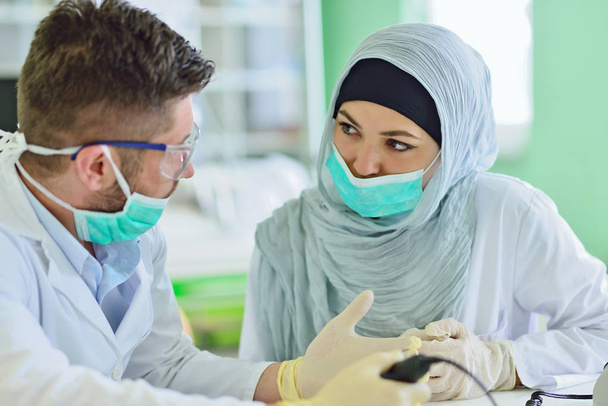Arab students with hijab while working on the denture, false teeth. - Фото, изображение