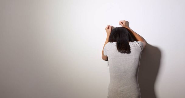 Γυναίκα αίσθημα αναστατωμένος και κραυγή ενάντια στον τοίχο  - Φωτογραφία, εικόνα