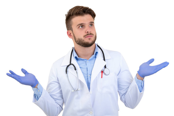 Jovem Surpreendido médico masculino posando em um uniforme branco isolado em fundo branco
 - Foto, Imagem